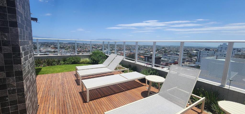 a balcony with two chairs and a view of a city at Dream Apartment-Rooftop, Pool, Mountain & Sea View in Capão da Canoa