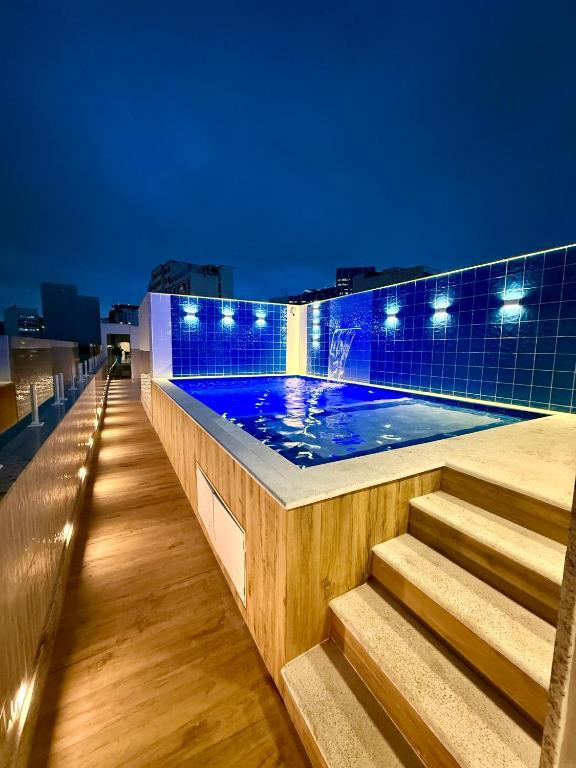 a swimming pool on the roof of a building at night at Hotel Sheik Business in Rio de Janeiro