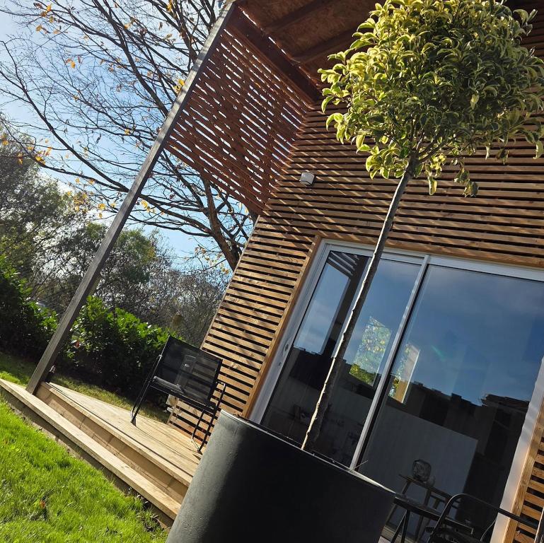 a house with a bench and a tree in front of it at Cottage Atypique in Saint-Laurent-de-la-Prée