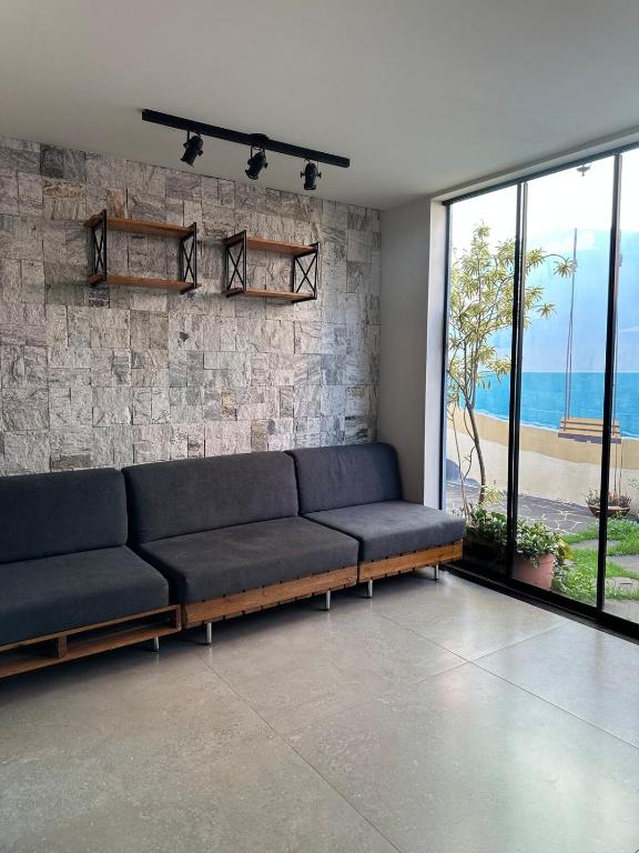 un salon avec un canapé et un mur en pierre dans l'établissement Casa Astral, à Uberlândia