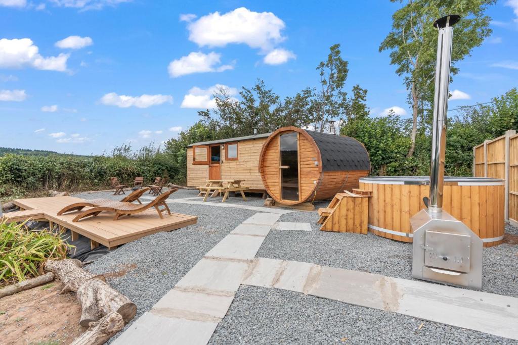 a cabin with a woodburning stove in a yard at Starry Nights Escape - Hot Tub & Sauna in Yarpole