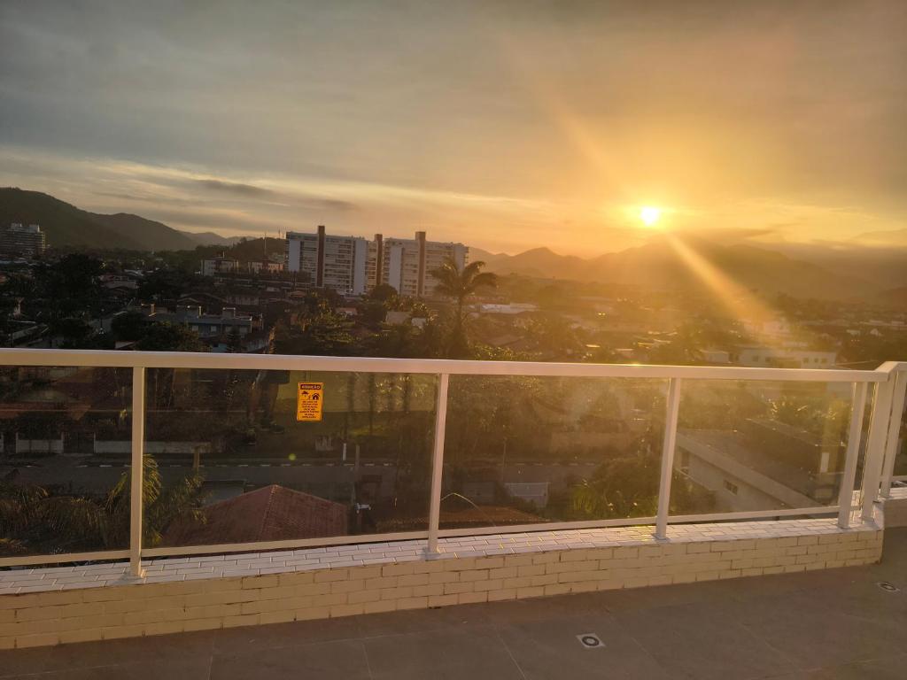 - un balcon offrant une vue sur le coucher du soleil dans l'établissement excelente Cobertura no centro de Bertioga, à Bertioga