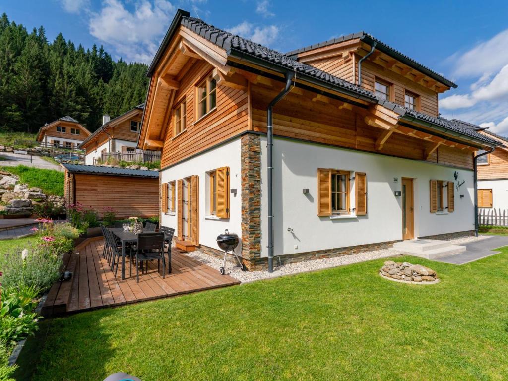 a wooden house with a deck and a yard at Auerhahn in Donnersbachwald