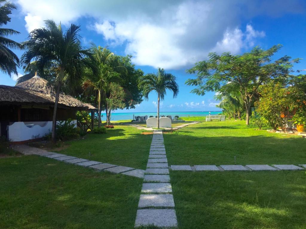 a pathway through a park with the ocean in the background at Amitie Chalets Praslin in Grand Anse