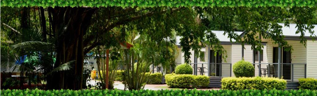 ein weißes Haus mit einem Baum davor in der Unterkunft Barrier Reef Tourist Park in Edmonton