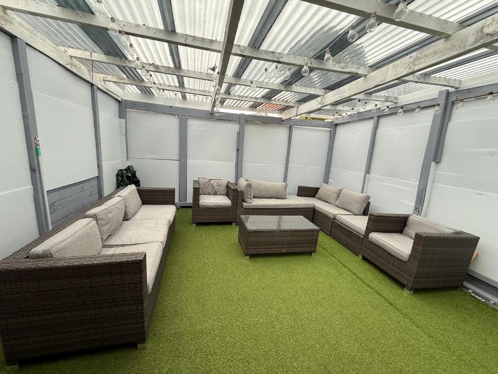 um quarto amplo com sofás, mesas e janelas em 2bed granny flat close to Auckland Airport em Auckland