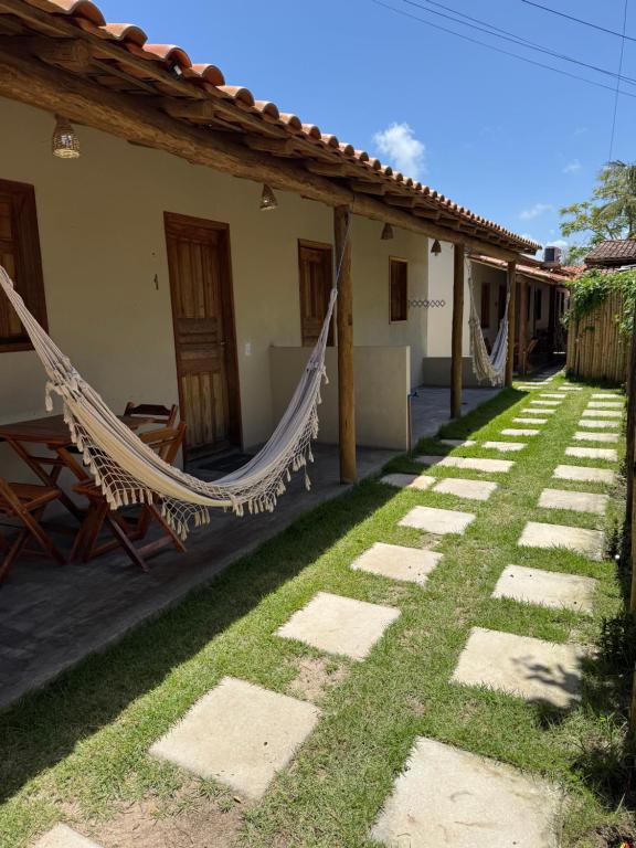 a house with a hammock in the yard at Vila Kairós in Caraíva