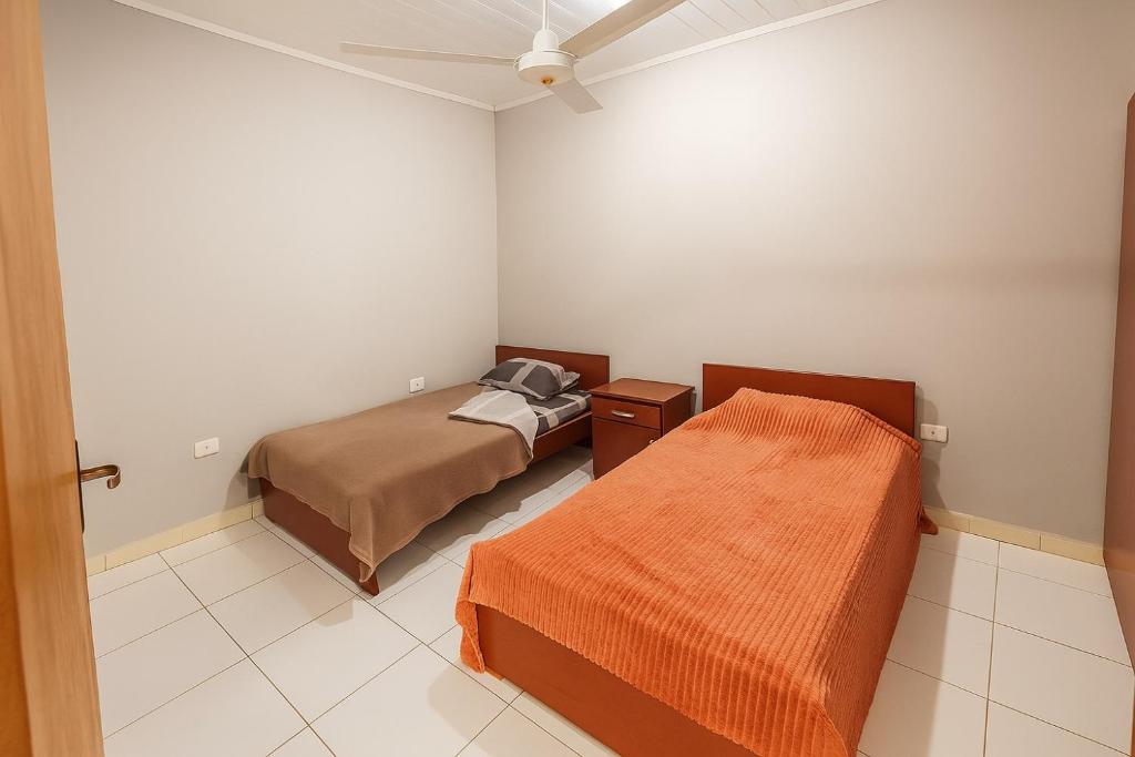 a bedroom with two beds and a ceiling fan at Complejo de Apartamentos parque naturaleza in Encarnación
