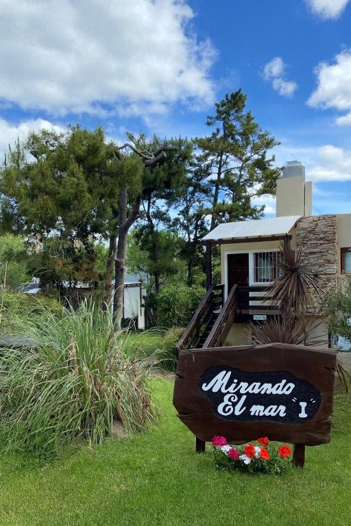 a sign in the grass in front of a house at Mirando al Mar I in Mar Azul