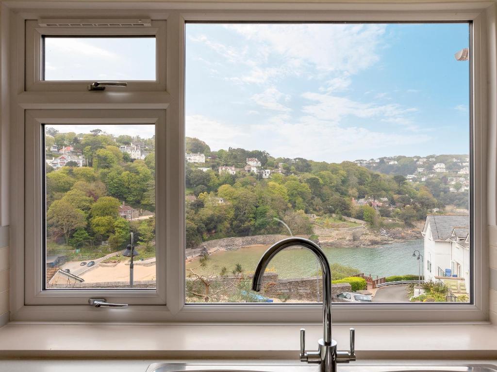 a window over a kitchen sink with a view of the water at Estuary House Flat 3 in Salcombe