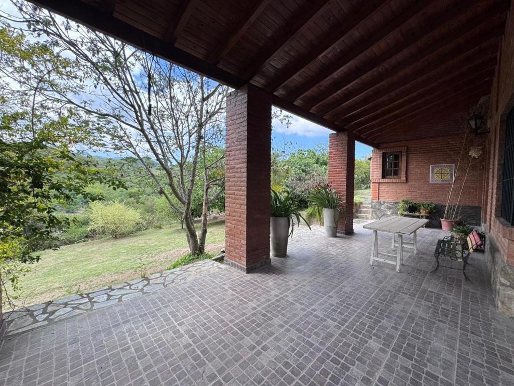 un patio extérieur avec une table et un banc dans l'établissement "Kalula" Casa de Campo en Raco, à Siambón