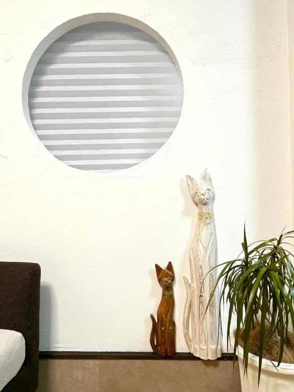 two cats sitting on a shelf next to a mirror at CatNook 猫ちぐら in Matsumoto