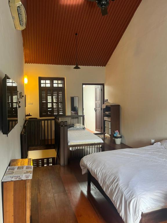 Qiyis Cottage في جورج تاون: غرفة نوم بسريرين وارضية خشبية