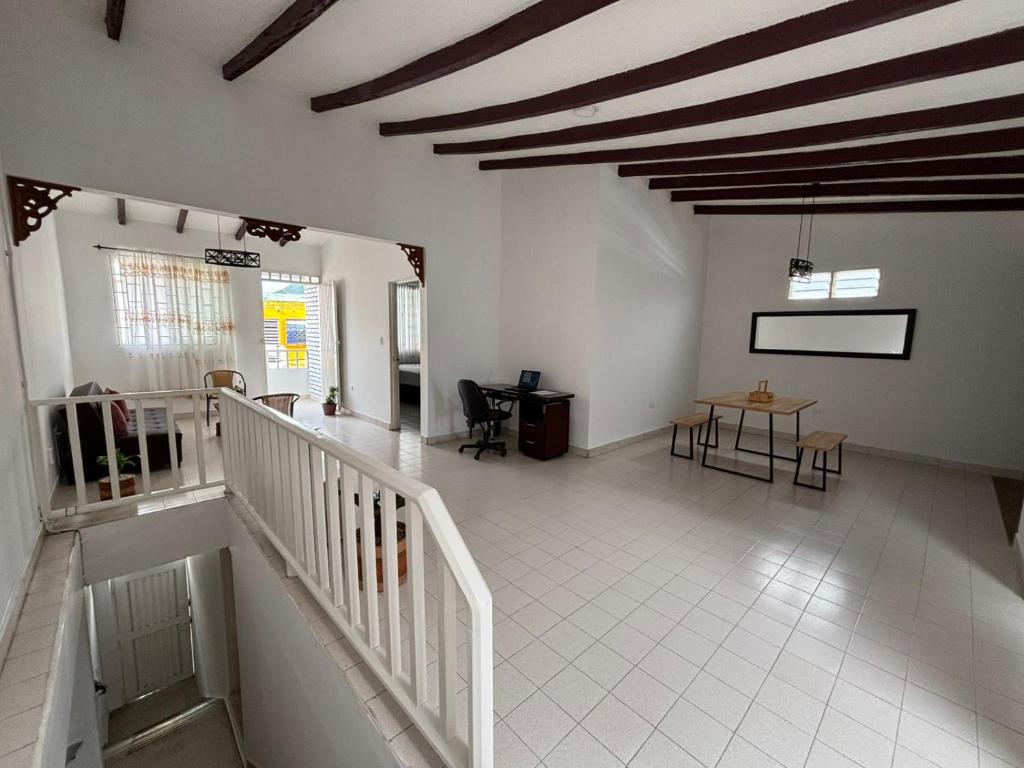 a room with a staircase and a table and chairs at Casa grande en el centro de Roldanillo in Roldanillo