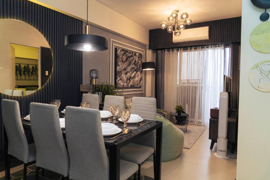 una sala da pranzo con tavolo, sedie e uno specchio di Casa Celestine Staycation a Manila