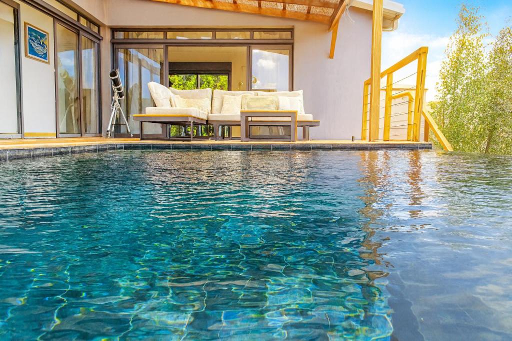 a swimming pool in front of a house at Villa privée - Piscine, Jacuzzi, Sauna & Hammam in Le Tampon