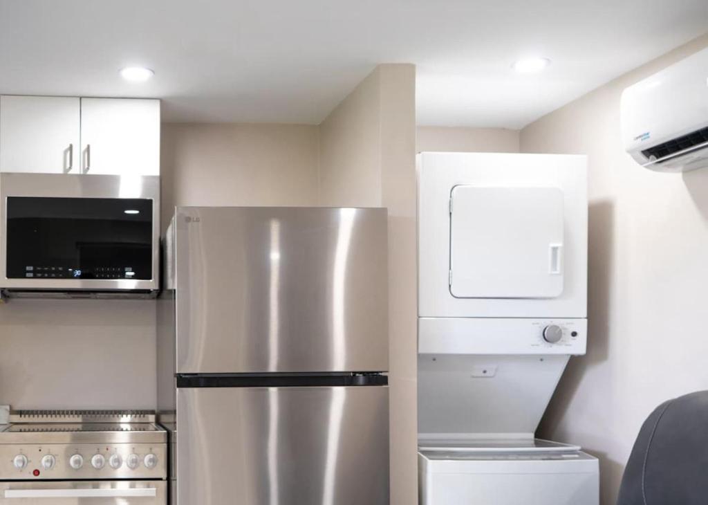 Una cocina con refrigerador de acero inoxidable y microondas. en Peace and Tranquility awaits, en Miami Gardens