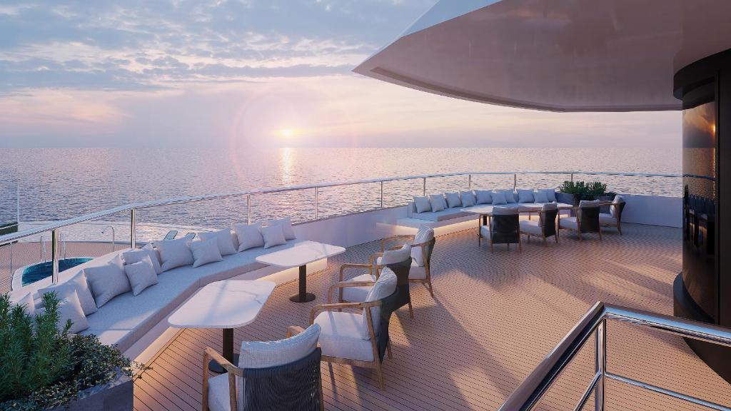 een balkon met tafels en witte stoelen op een cruiseschip bij AIME'E CRUISES - Halong Bay in Ha Long