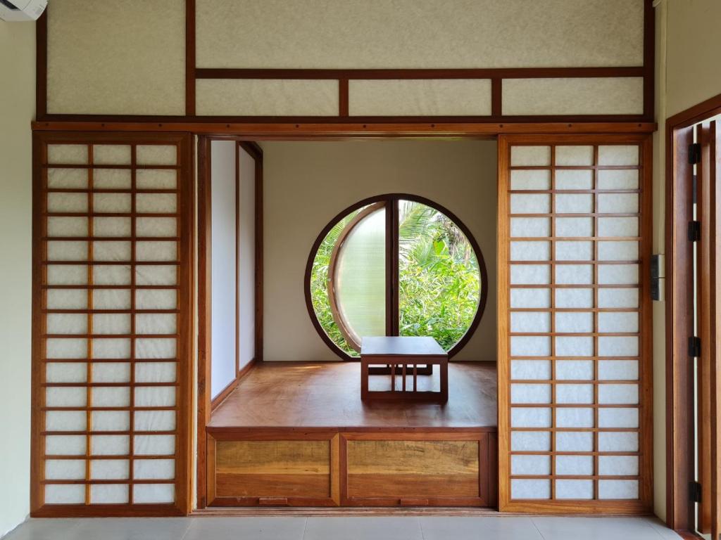 Cette chambre dispose d'une fenêtre et d'une chaise. dans l'établissement InnerZen Riverside homestay Ben Tre 1 bedroom for 1-2 guests, 2 bedrooms for 3-4 guests, à Ấp Phú Hòa (3)