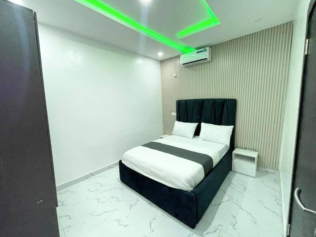 ein Schlafzimmer mit einem Bett und einem grünen Licht in der Unterkunft Luxurious 2bedroom Apartment PS5 in Ibadan