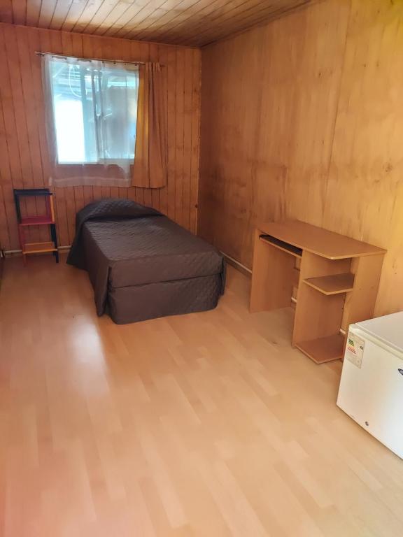 コンセプシオンにあるHabitación individual para hombres 'のベッドと机のある小さな部屋