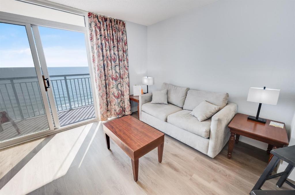 a living room with a couch and a large window at Roxanne Towers Remodeled with Amazing Views,Pools! in Myrtle Beach