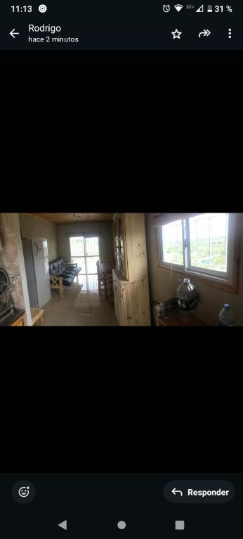 een foto van een woonkamer en een keuken bij Cabaña Flor Serrana in Tanti