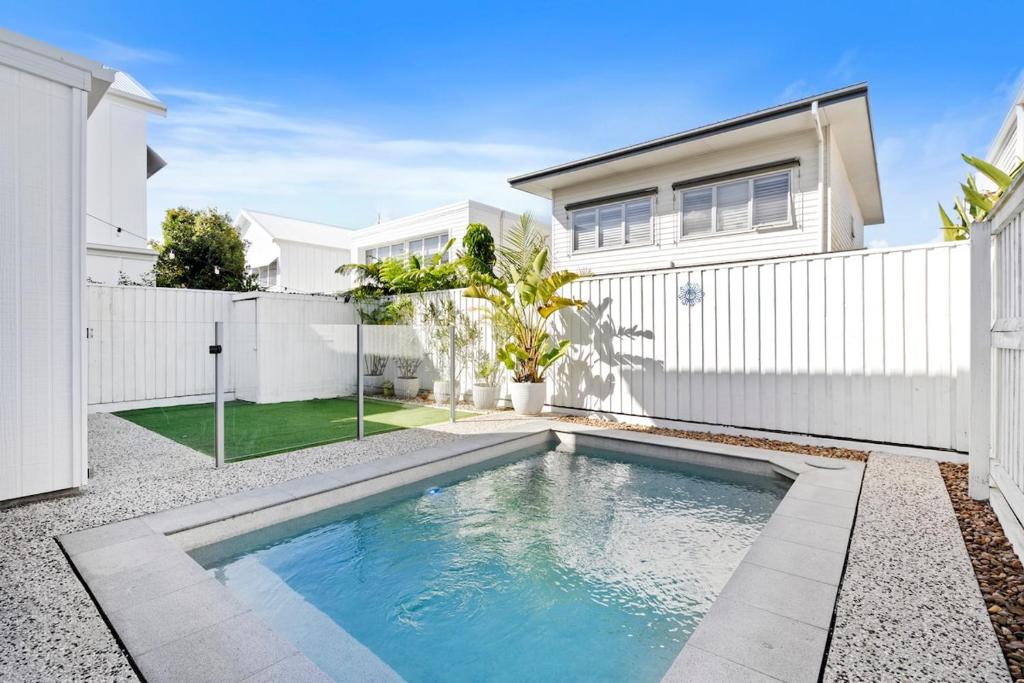 a swimming pool in front of a white fence at Seabreeze in Kingscliff