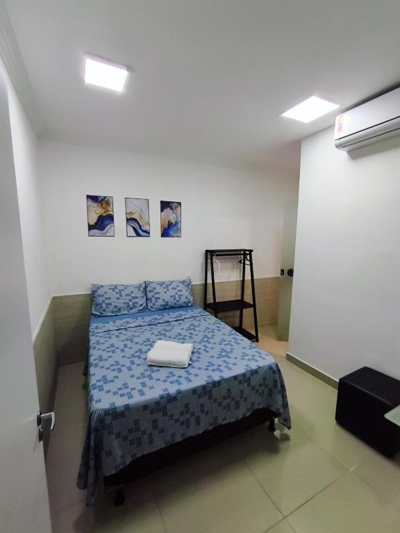 a bedroom with a bed with a blue comforter at Essenza Suites Natal in Natal