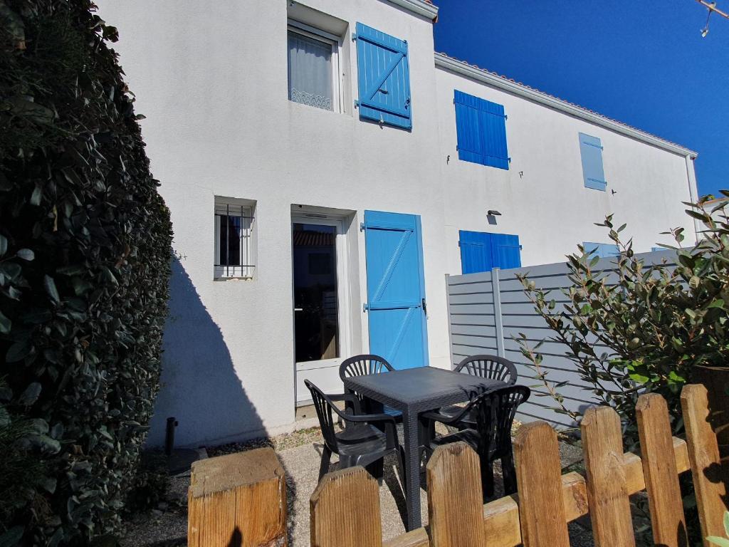 une table et des chaises devant un bâtiment blanc dans l'établissement Maisonnette conviviale proche plage pour 4 pers. - FR-1-476-174, à La Faute-sur-Mer