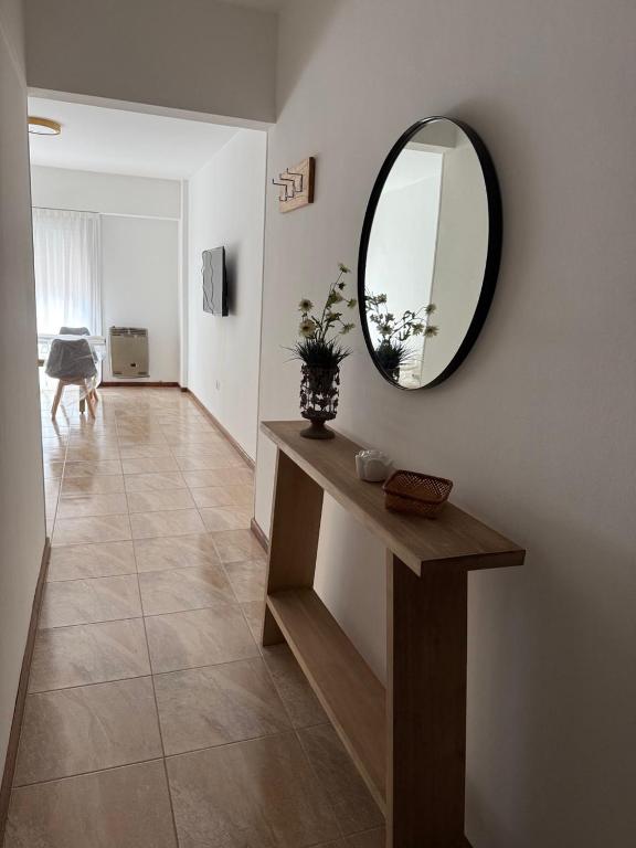 a living room with a mirror and a table at Departamento en Chivilcoy in Chivilcoy