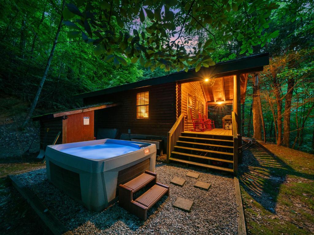 une petite maison avec un bain à remous en face de celle-ci dans l'établissement Good Life Cabin 2, à Bryson City
