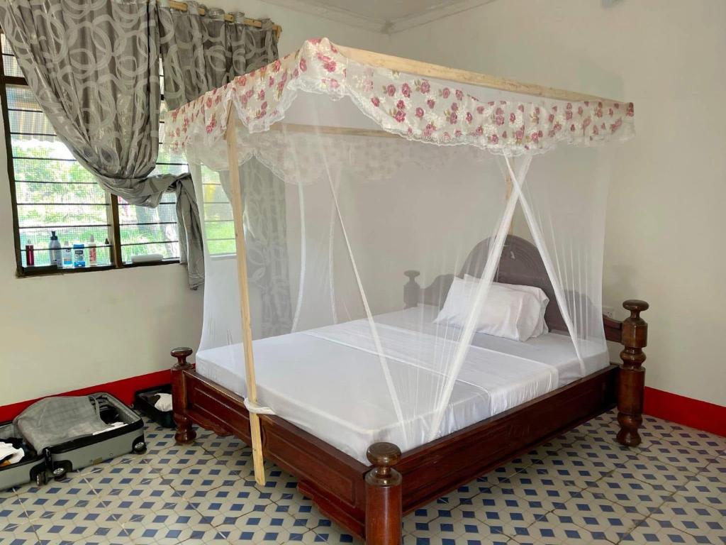 a bed with a canopy in a room at Camp Zora Selous in Kwangwazi