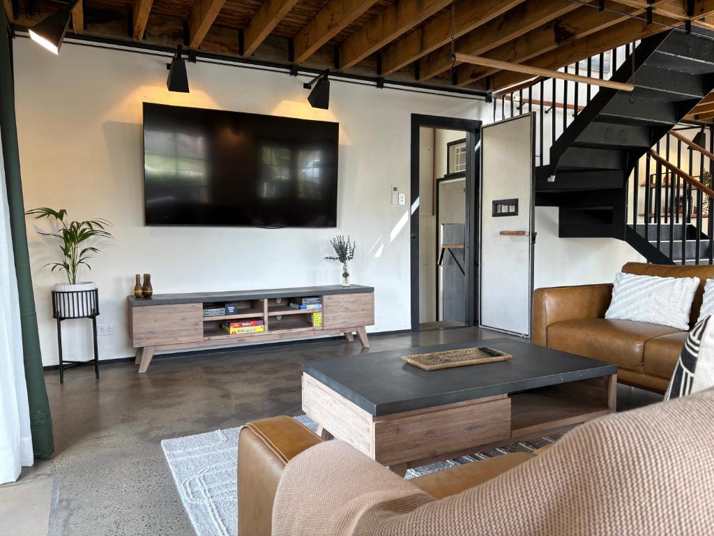 un soggiorno con un divano e una TV a parete di The Podium Accommodation - Oatlands, Tasmania a Oatlands