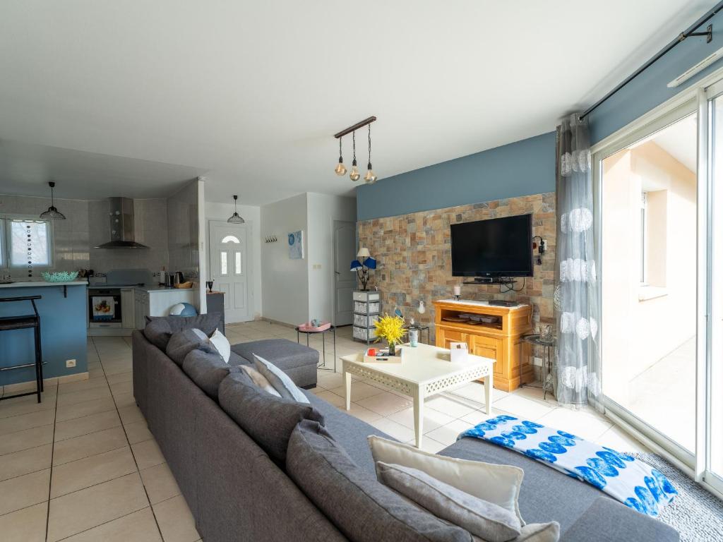 un salon avec un canapé et une télévision dans l'établissement Maison spacieuse à 600m du lac, 8 pers., piscine - FR-1-50-161, à Aureilhan