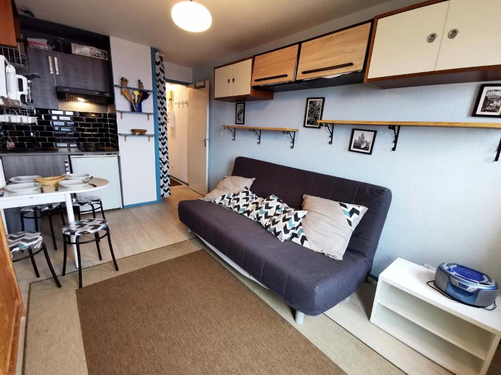 a living room with a couch and a small kitchen at Studio rénové, balcon vue vallée, proche centre et remontées - FR-1-771-1 in Les Adrets
