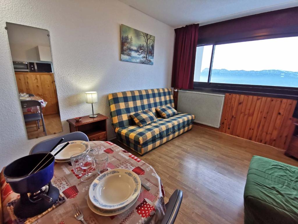 Les AdretsStudio confortable pied des pistes, animaux interdits - FR-1-771-6的客厅里有一张桌子和一张沙发