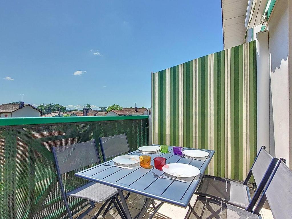 une table bleue avec des assiettes et des boissons sur un balcon dans l'établissement Appartement T3 avec Climatisation et Parking à Soustons - FR-1-857-19, à Soustons
