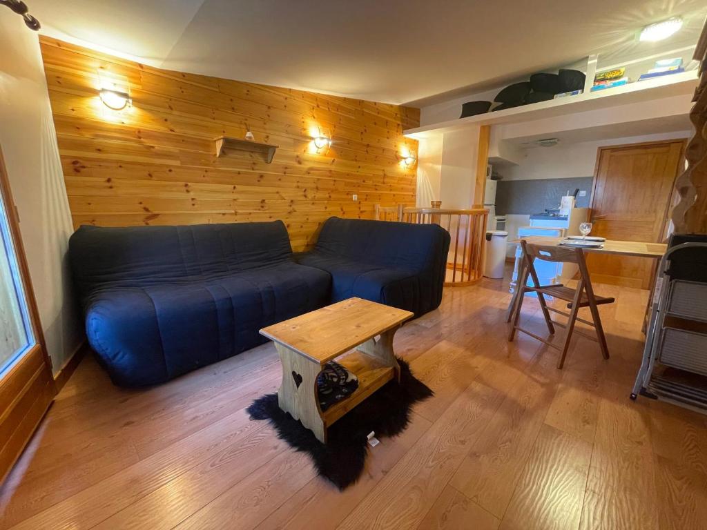 普华露Appartement familial à Pra-Loup 1600 proche des pistes - FR-1-165A-209的客厅里有一张蓝色的沙发和一张桌子