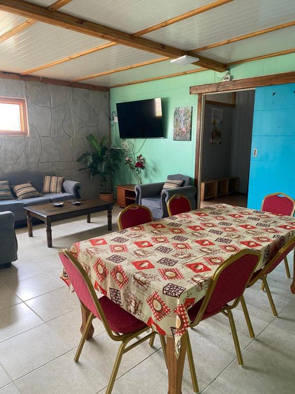 a living room with a table and chairs and a couch at Cabañas las Palmeras de Colbun in Linares