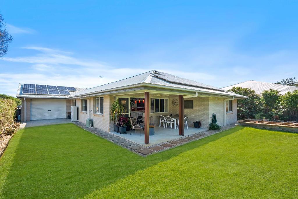 ein Haus mit Terrasse und Rasen in der Unterkunft The Wren's Nest in Sandstone Point