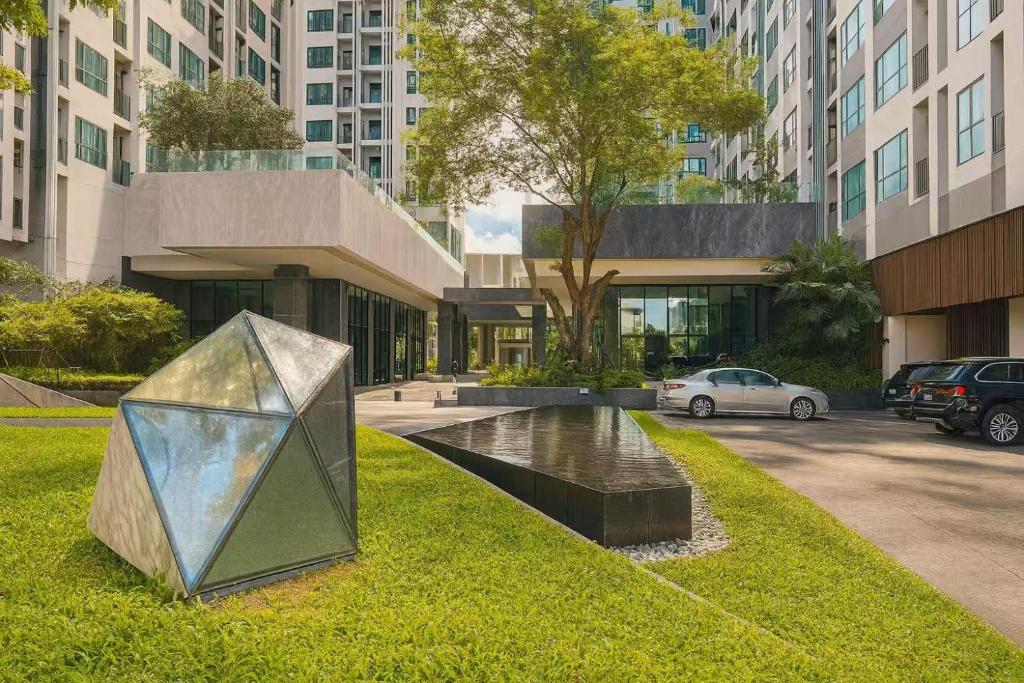 a sculpture on the grass in front of a building at 芭提雅市中心度假公寓 The Base预定 免费游泳池健身房 生活购物便利 in Pattaya Central