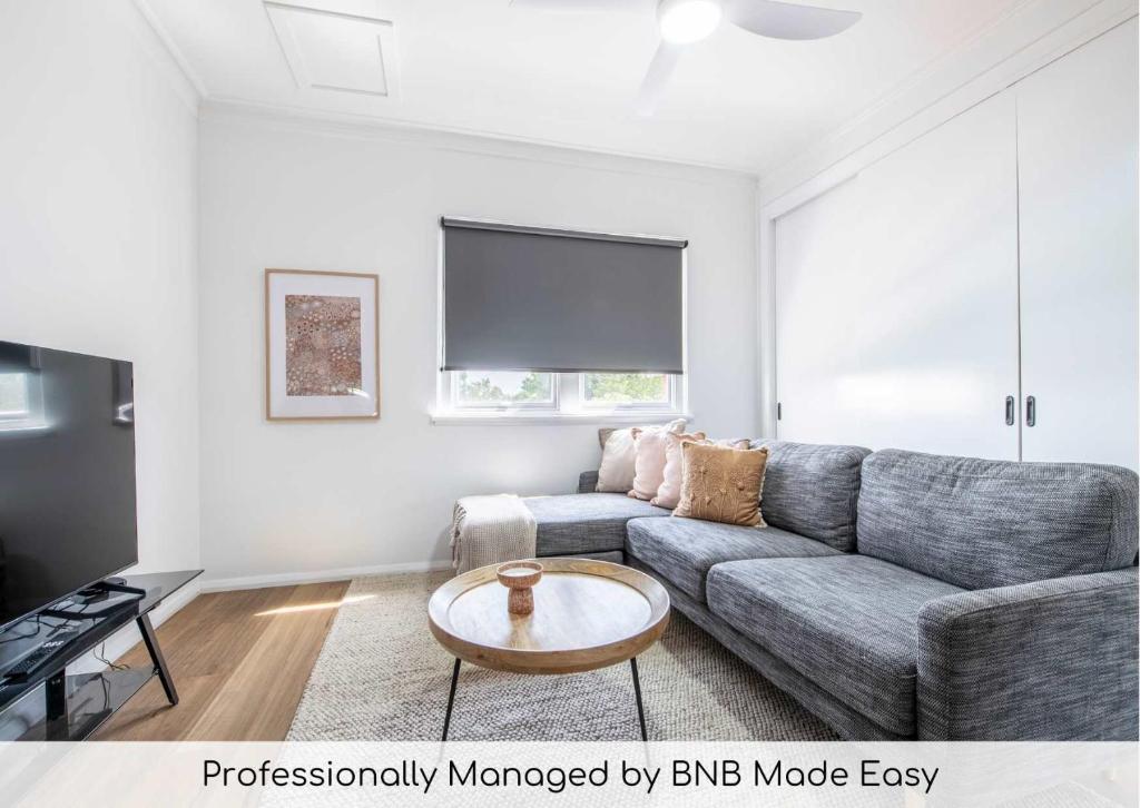 a living room with a couch and a table at Tamworth Loft - Cosy & Convenient, Ideal for Work in Dubbo
