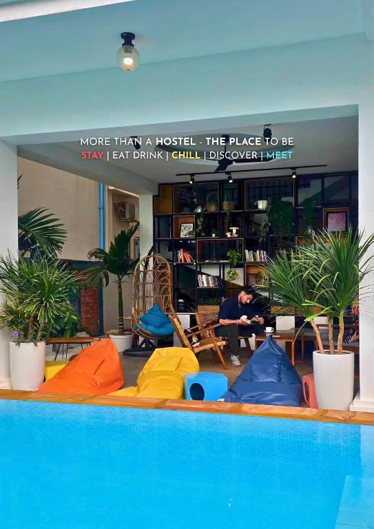 una piscina con colchonetas de colores en una habitación con plantas en THE PLACE Hostel Siem Reap Angkor, en Siem Reap