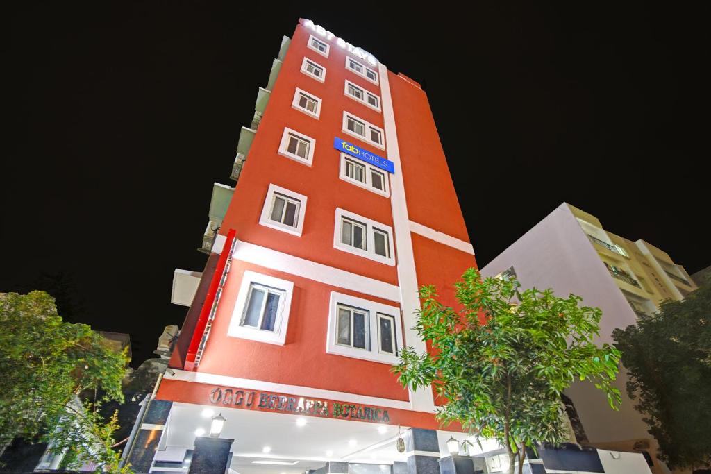 a tall orange building with white windows at Hotel Abhimanyu Villa in Hyderabad