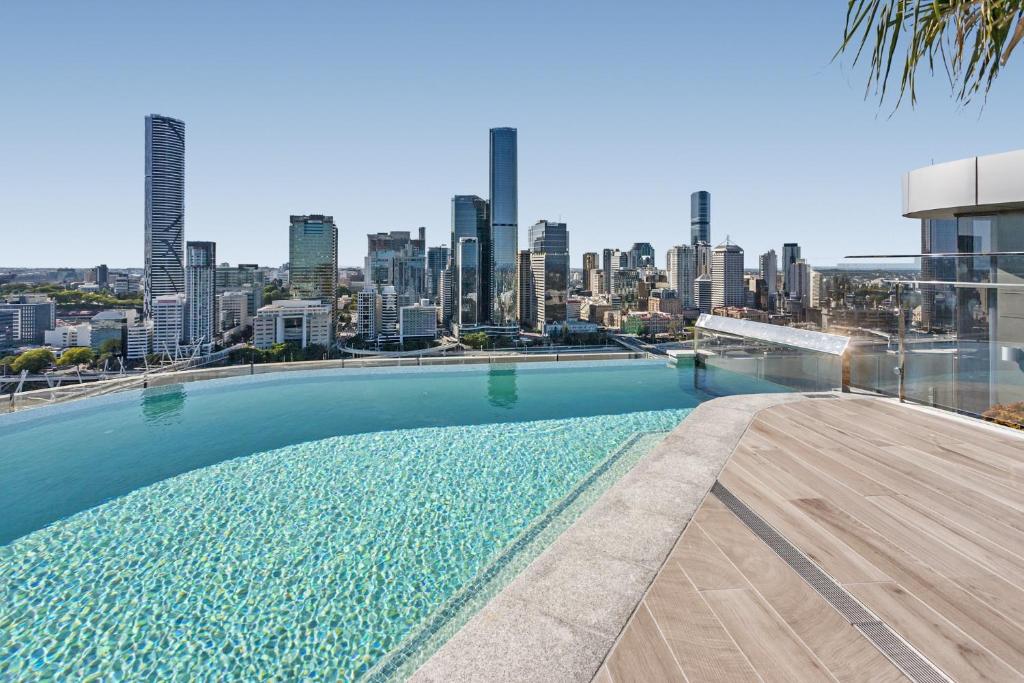 a swimming pool on top of a building with a city skyline at River-View Unit with Rooftop Pool near Museums in Brisbane
