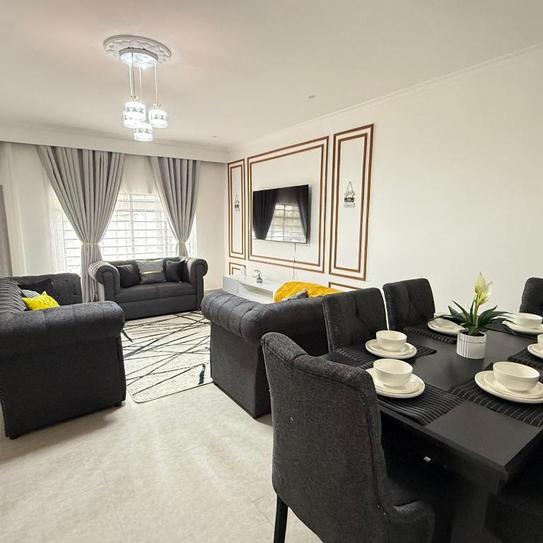 a living room with a black table and chairs at Rest Haven Apartments Meanwood in Lusaka