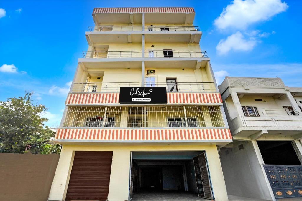 a tall yellow building with a sign on it at Collection O Rajgir Railway Junction Formerly Hotel Mamta Kutir in Rājgīr