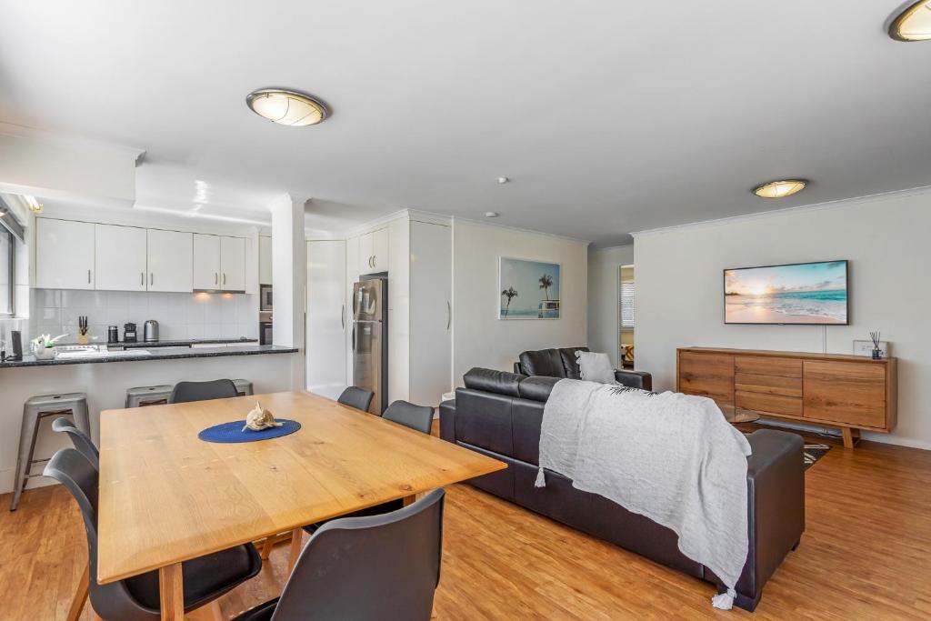 una sala de estar con una mesa y un sofá en Cosy 2-Bedroom Seaside Unit Steps from Beach, en Maroochydore