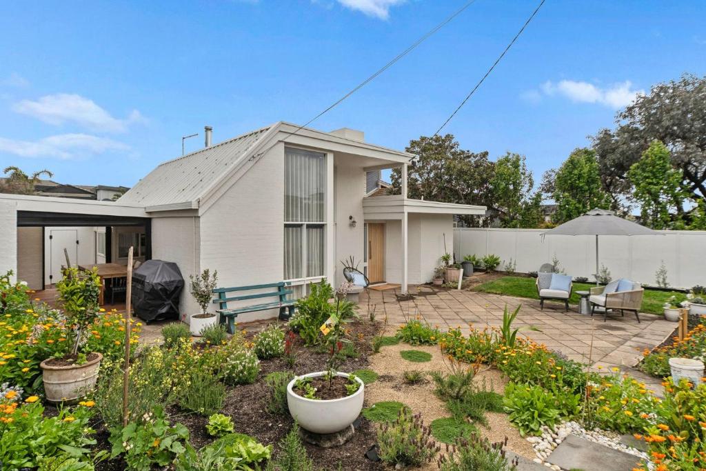 ein Haus mit einem Garten davor in der Unterkunft The Tides - Luxe Beach House Mornington in Mornington